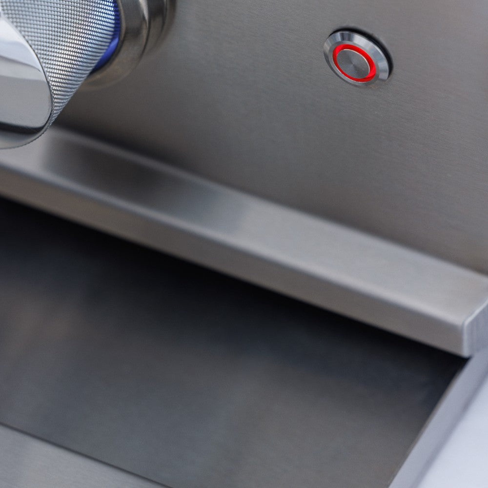 Stainless steel gas grill control area with knobs and red ignition indicator