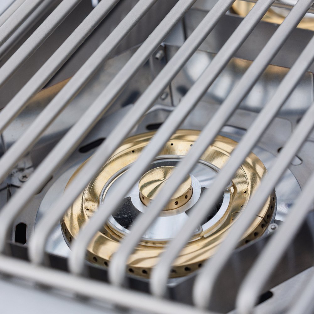 Double side burner with brass burner ports under metal grate