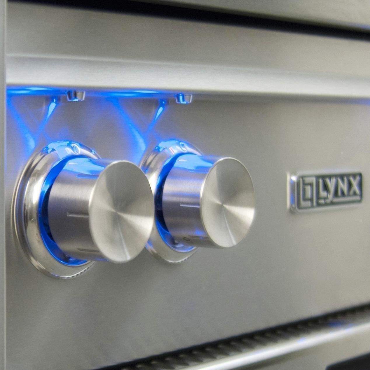 Gas grill control panel with two stainless knobs, blue light, and Lynx logo