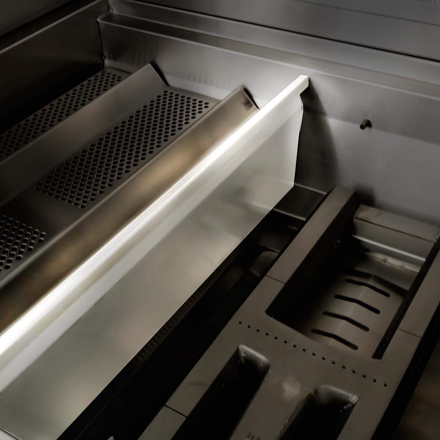 Stainless steel grill interior showing rear vent and warming or heat area