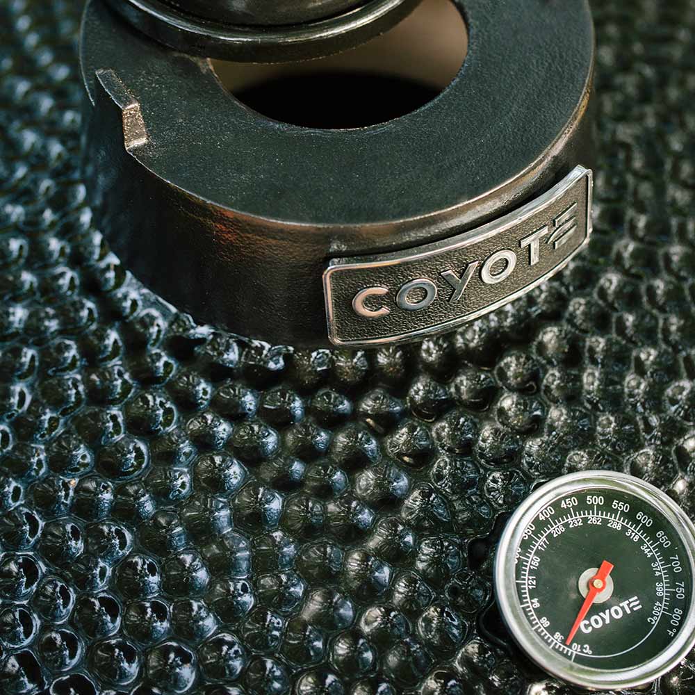 Close-up of black ceramic smoker with Coyote badge and circular thermometer