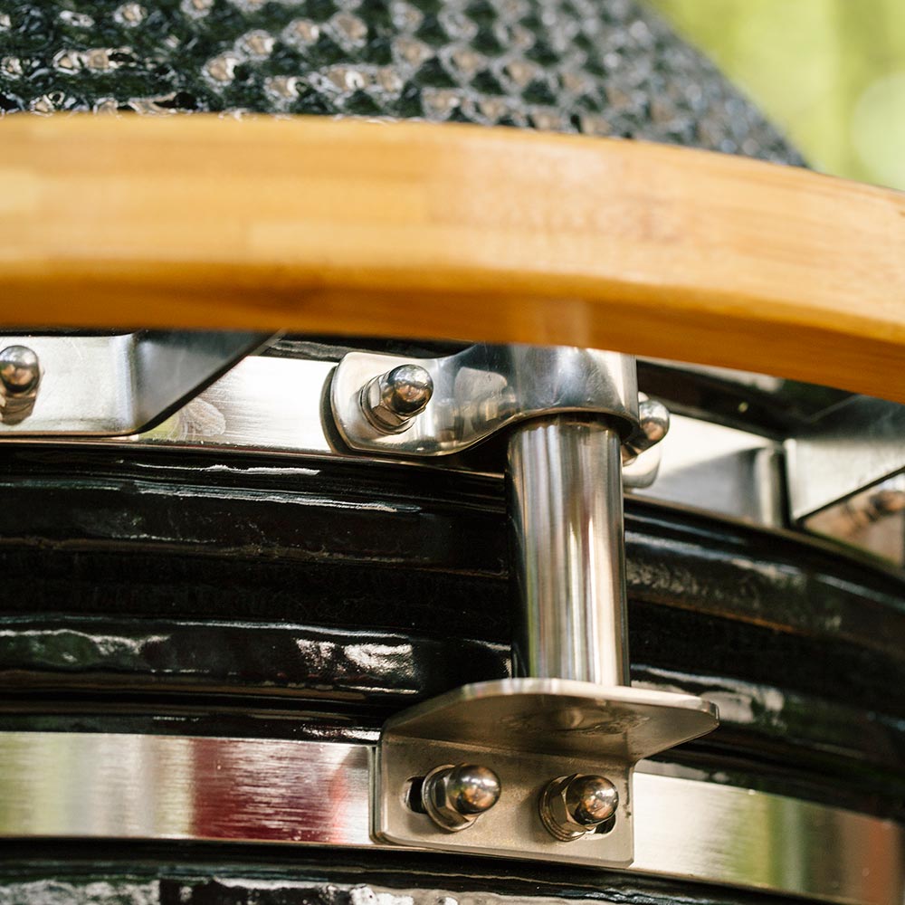 Close-up of smoker side shelf hardware with wood handle and brushed metal bracket