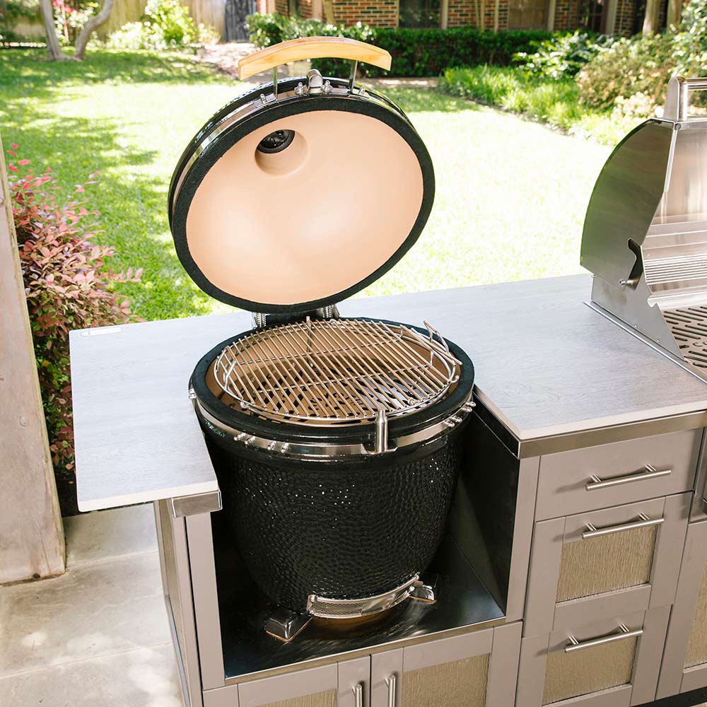 Ceramic asado smoker open on built-in counter, wire cooking rack visible, black body