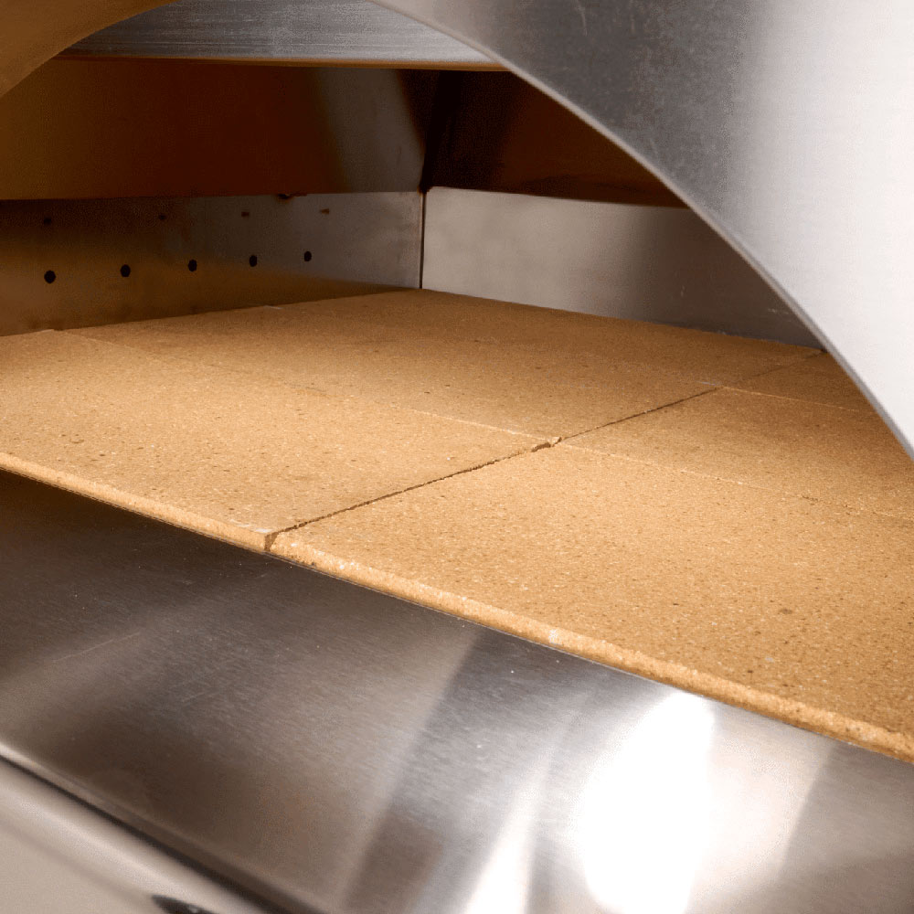 Pizza oven cooking chamber with stone baking surface and curved metal sides