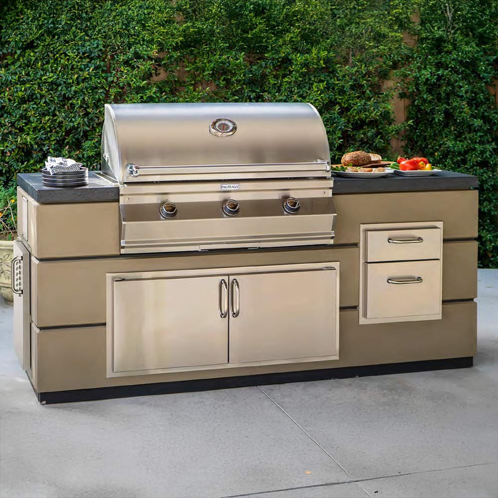 Stainless built-in gas grill with cabinet doors and side drawers, outdoor-ready design.