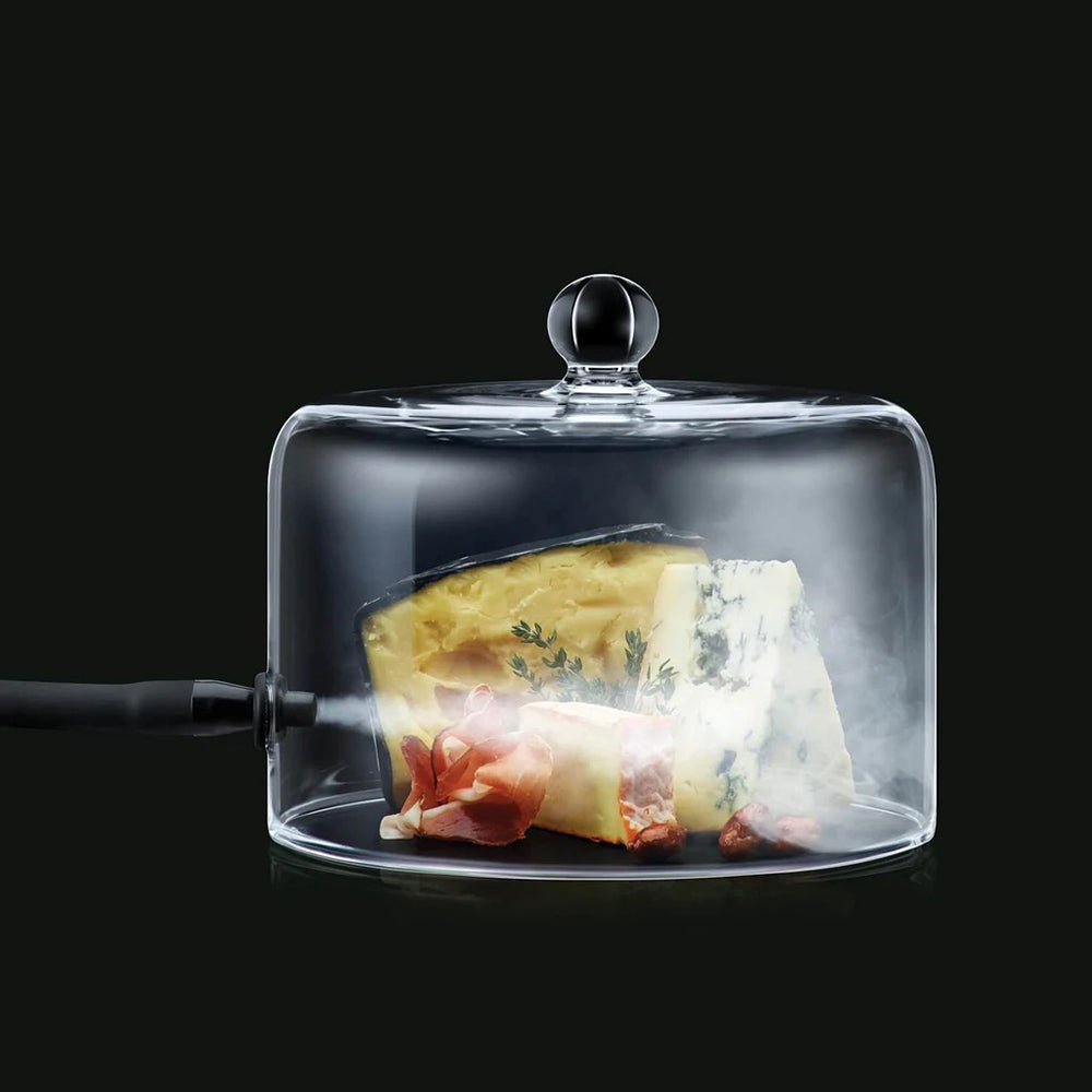 Clear cloche dome covering plated food with visible smoke vapor