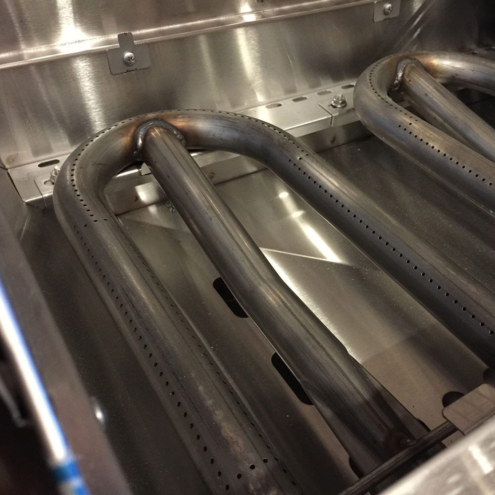 Gas grill burner assembly with metal tubes and heat shield baffles