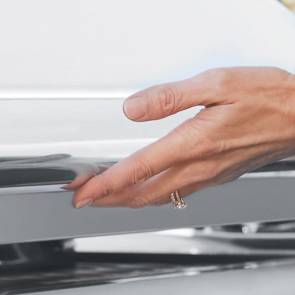 Gas grill control panel with hand adjusting a knob
