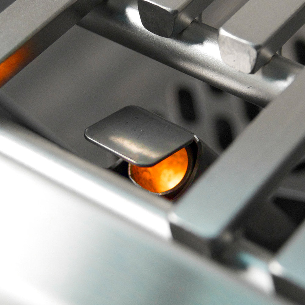 Gas flame inside a stainless steel grill burner compartment