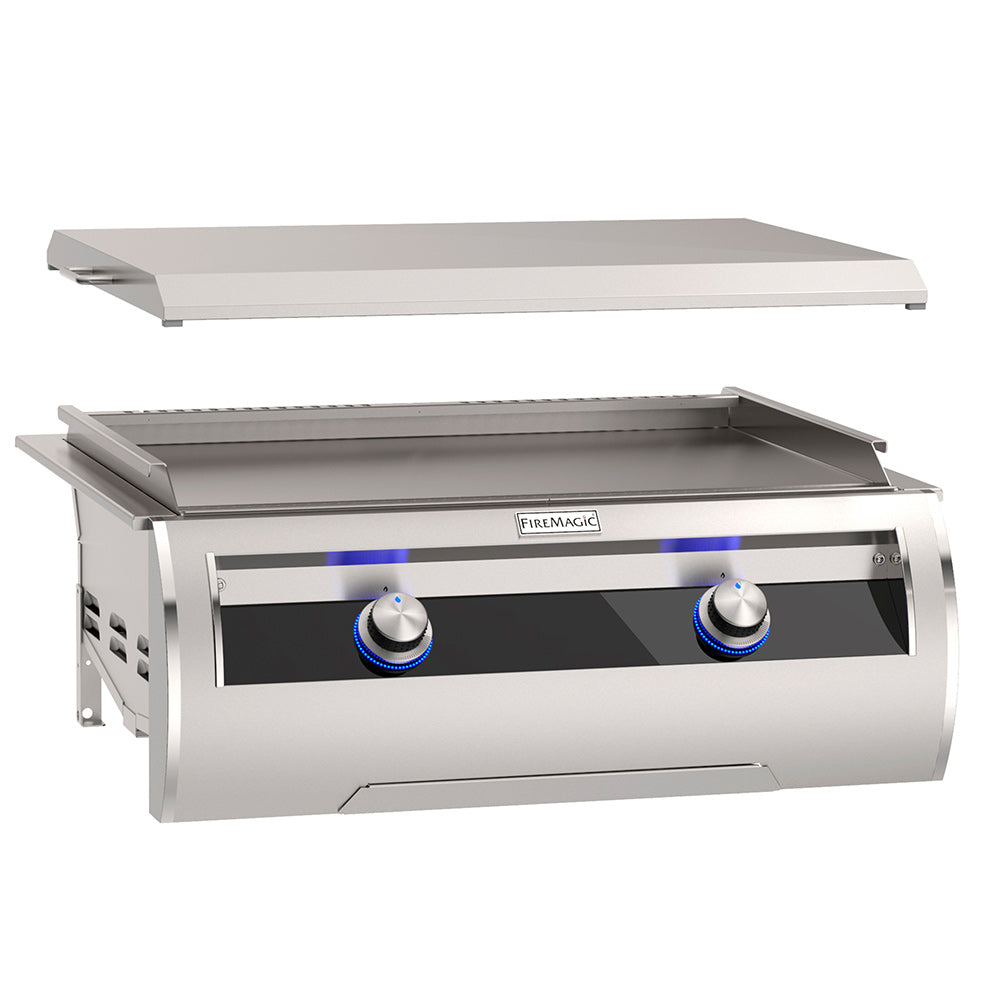 Built-in gas griddle with open lid and two blue control knobs on black panel