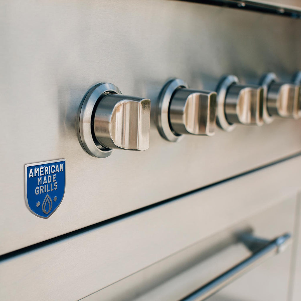 Stainless rotisserie rod assembly with American Made Grills badge on grill panel