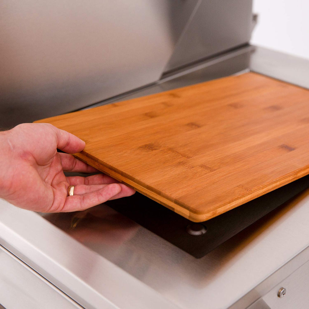 Wood side shelf on a dual fuel grill, shown folded out on the side.