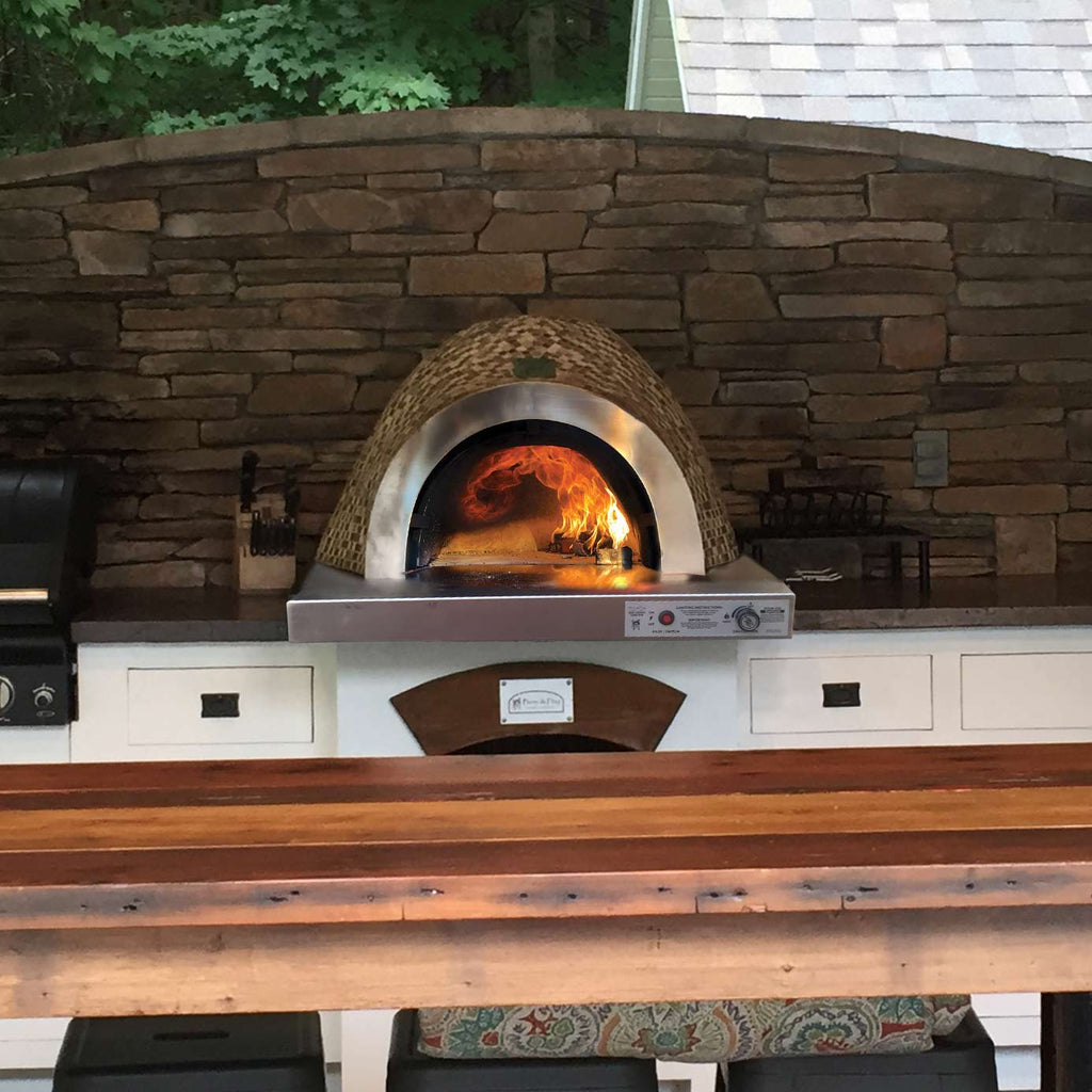 Built-in glass tile pizza oven with arched dome and open flame inside on counter