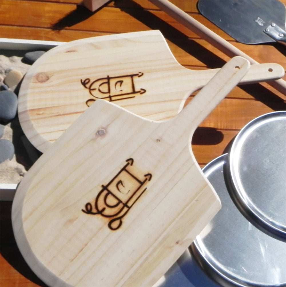 Engraved wooden pizza paddle with handle, light pine color.