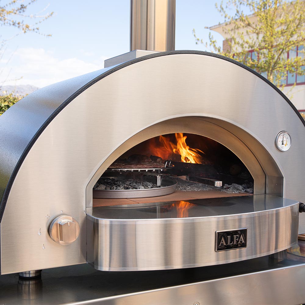Stainless wood-fired pizza oven front with open flame inside