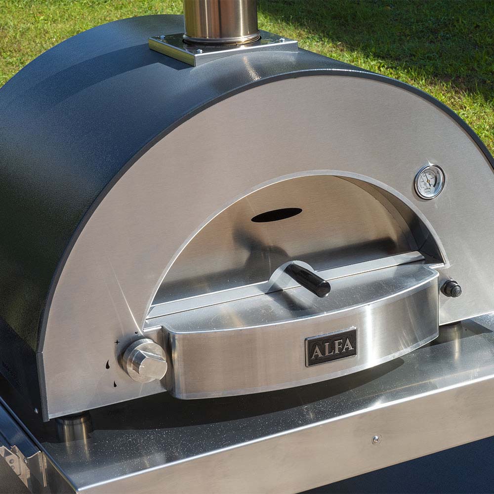Wood-fired pizza oven front with loading door and stainless shovel