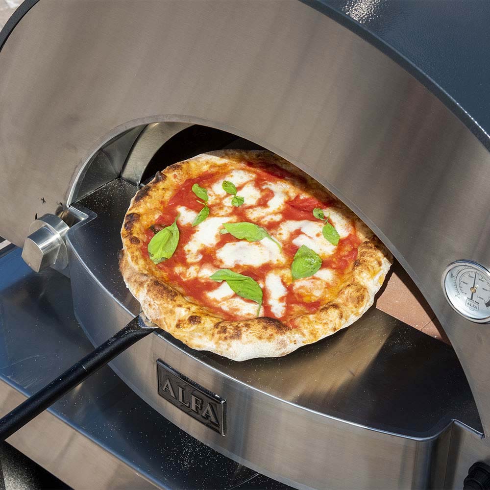 Wood-fired pizza oven with topped pizza baking inside the chamber