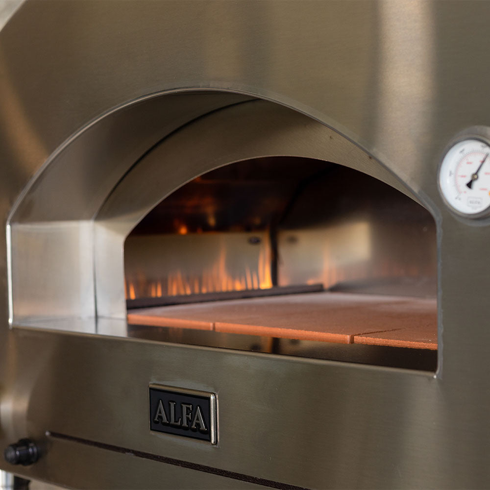Pizza oven interior view with glowing flames and baking stone inside the arched door.