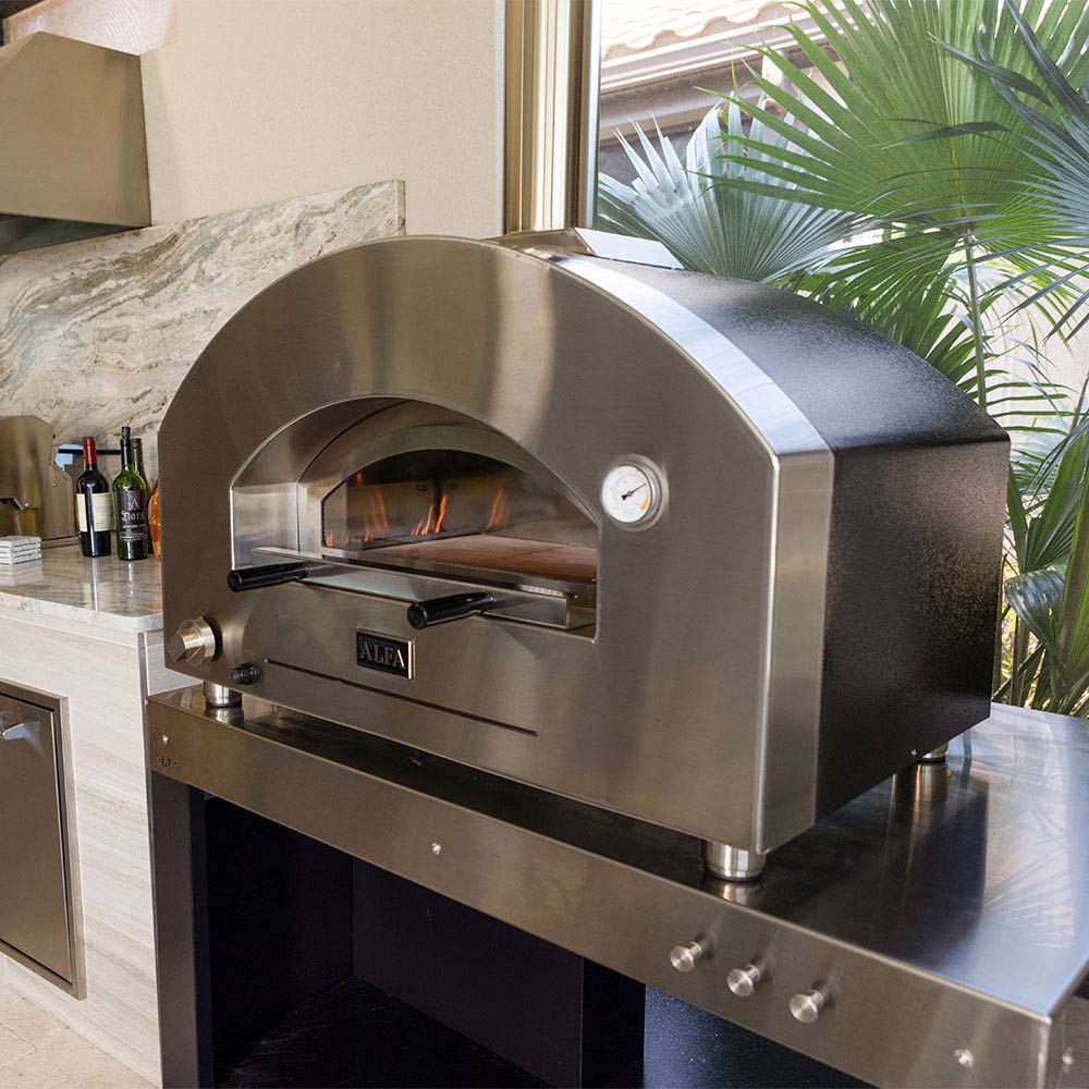 Stainless pizza oven head with arched opening, control dial on the right, and fire inside.