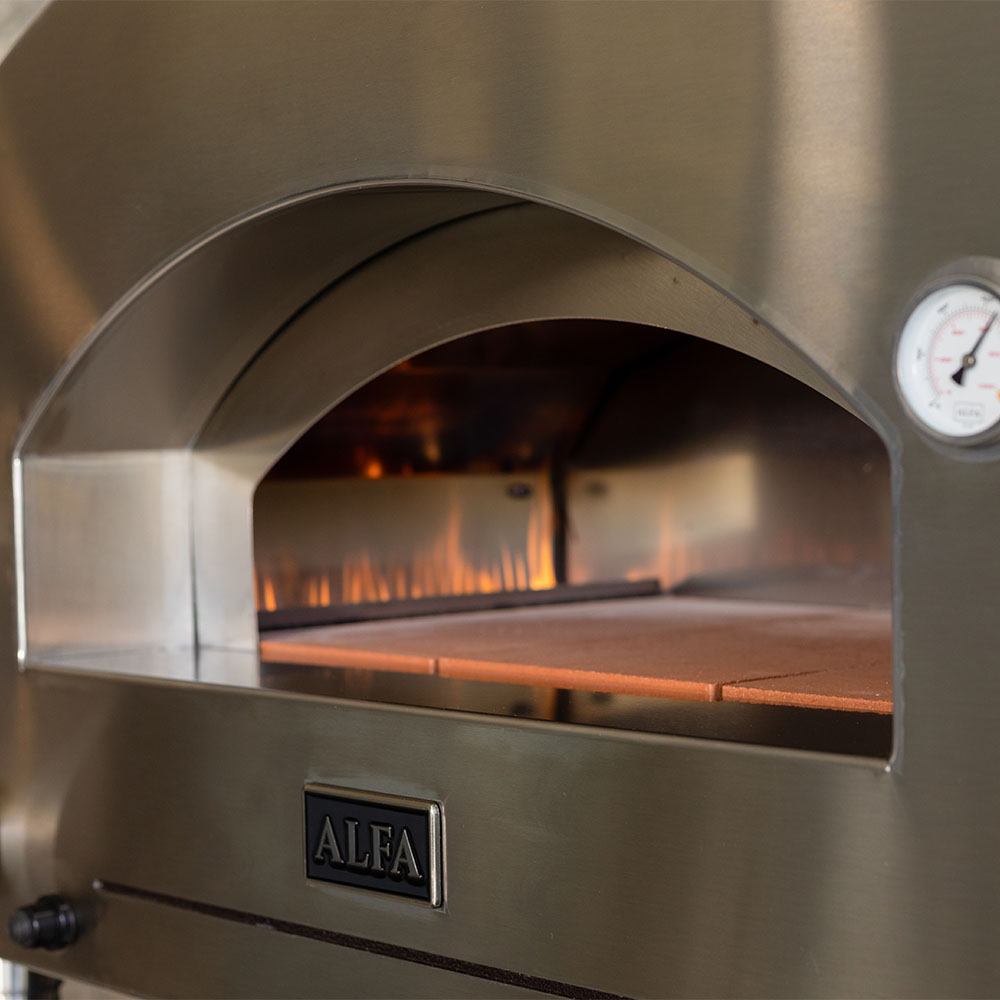 Gas pizza oven interior with open dome, glowing flames, and stone baking deck