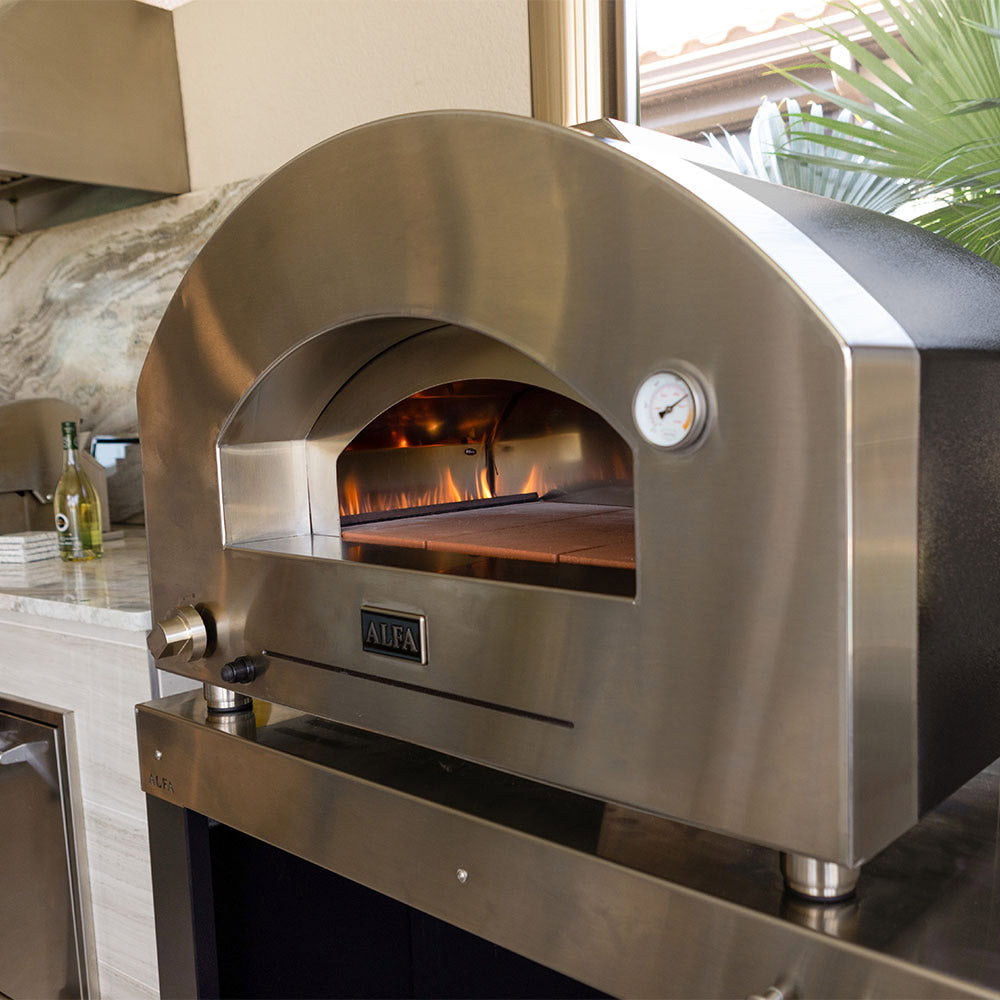 Stainless steel gas pizza oven front view with open chamber and visible flame interior
