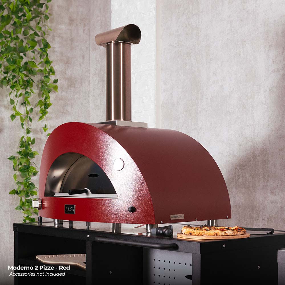 Red pizza oven with tall chimney and pizza on the base shelf