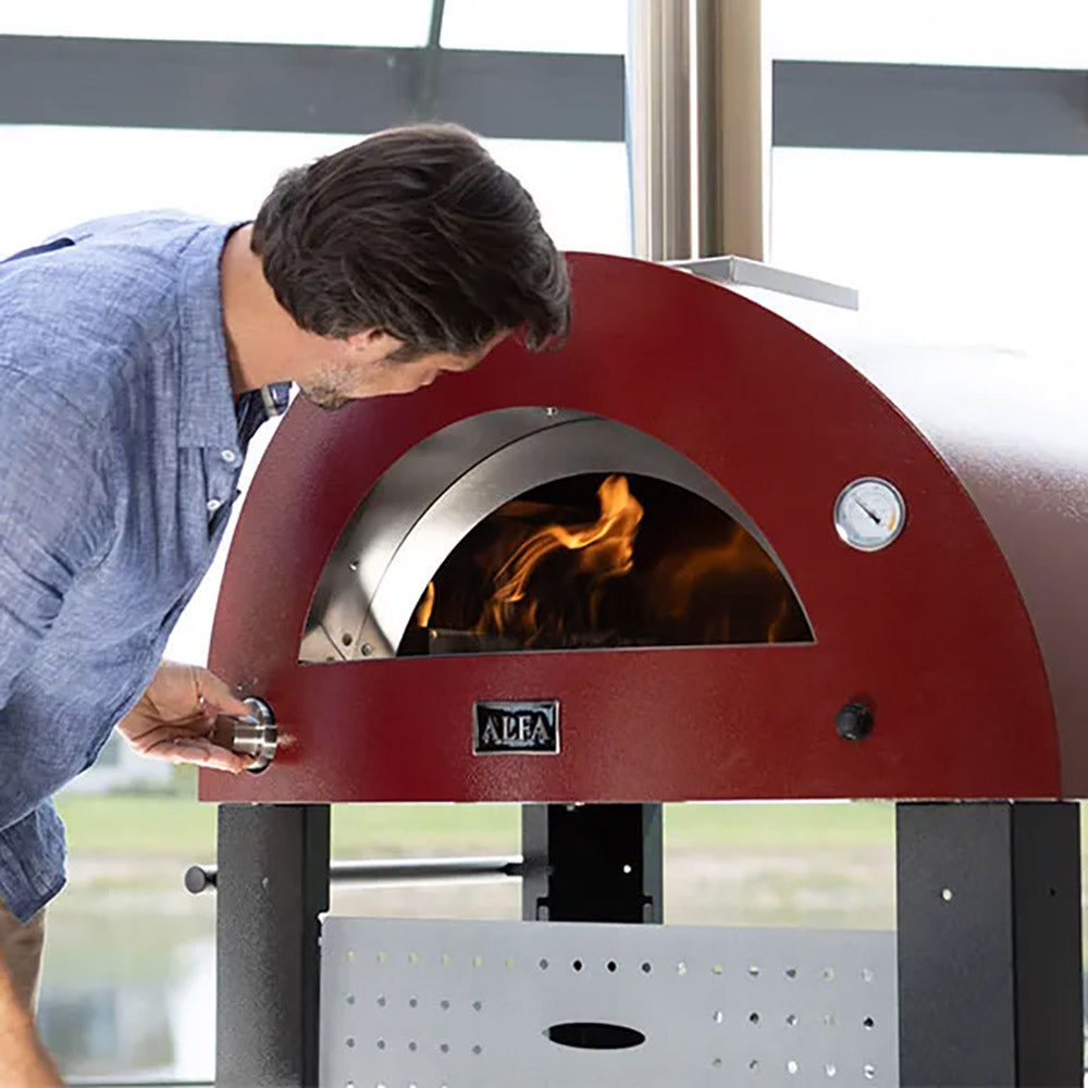 Open front of ruby red gas pizza oven with visible flames inside