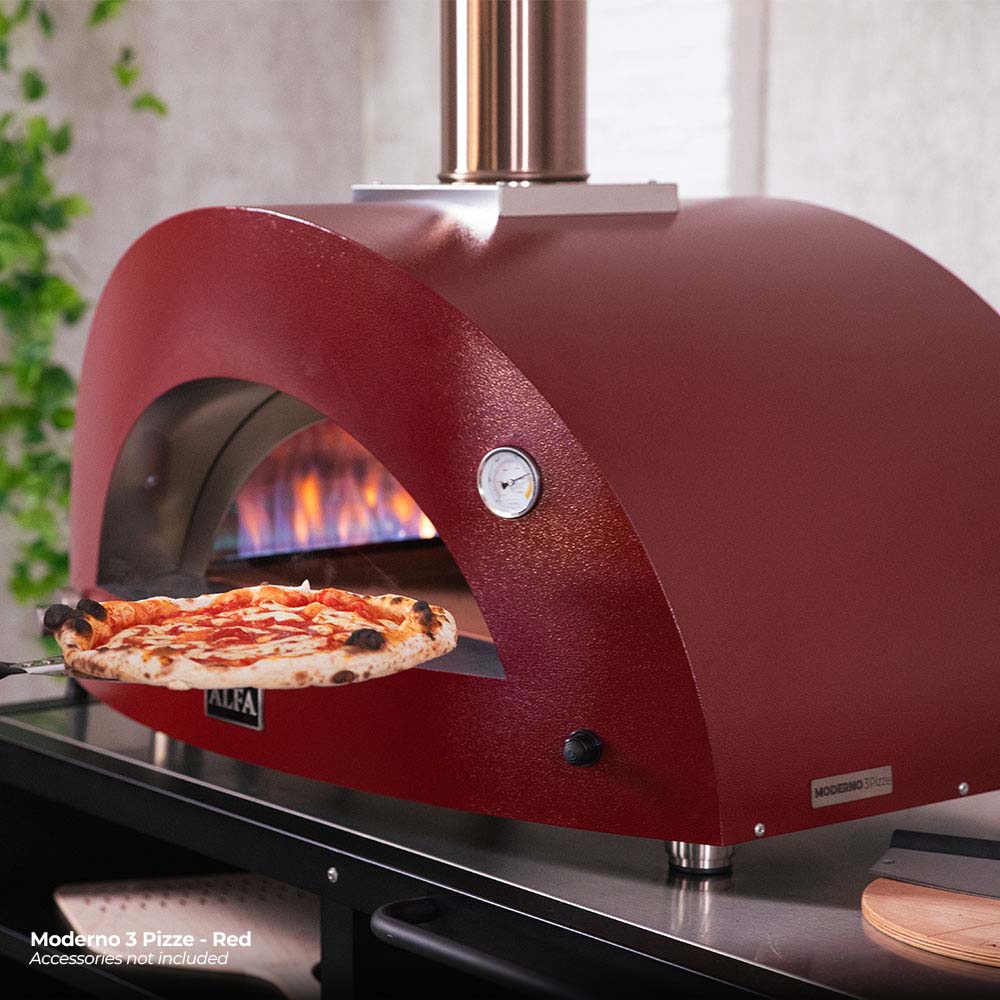 Ruby red gas pizza oven with lit flame and pizza resting inside arched opening