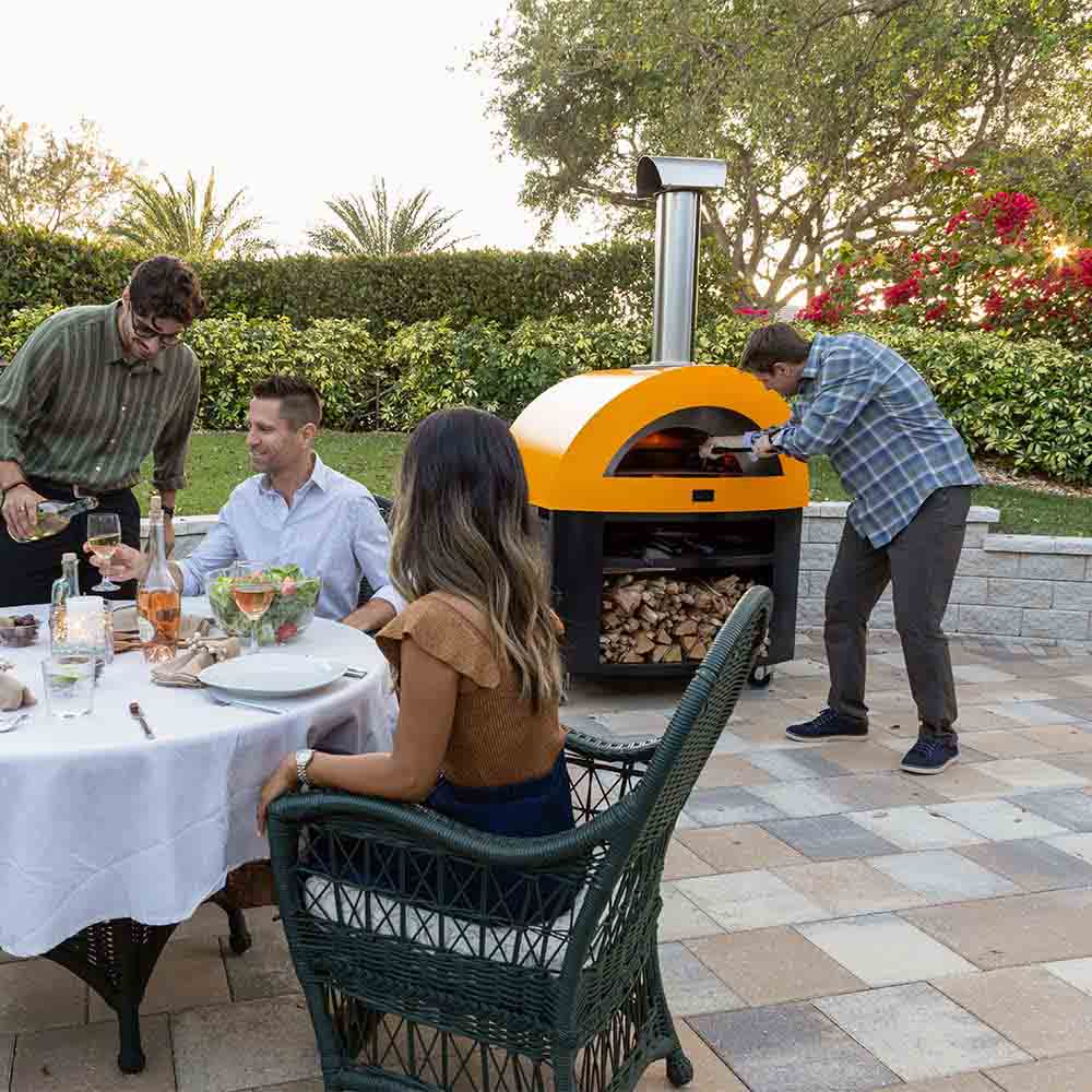 Freestanding wood-fired pizza oven with yellow dome and open front firebox