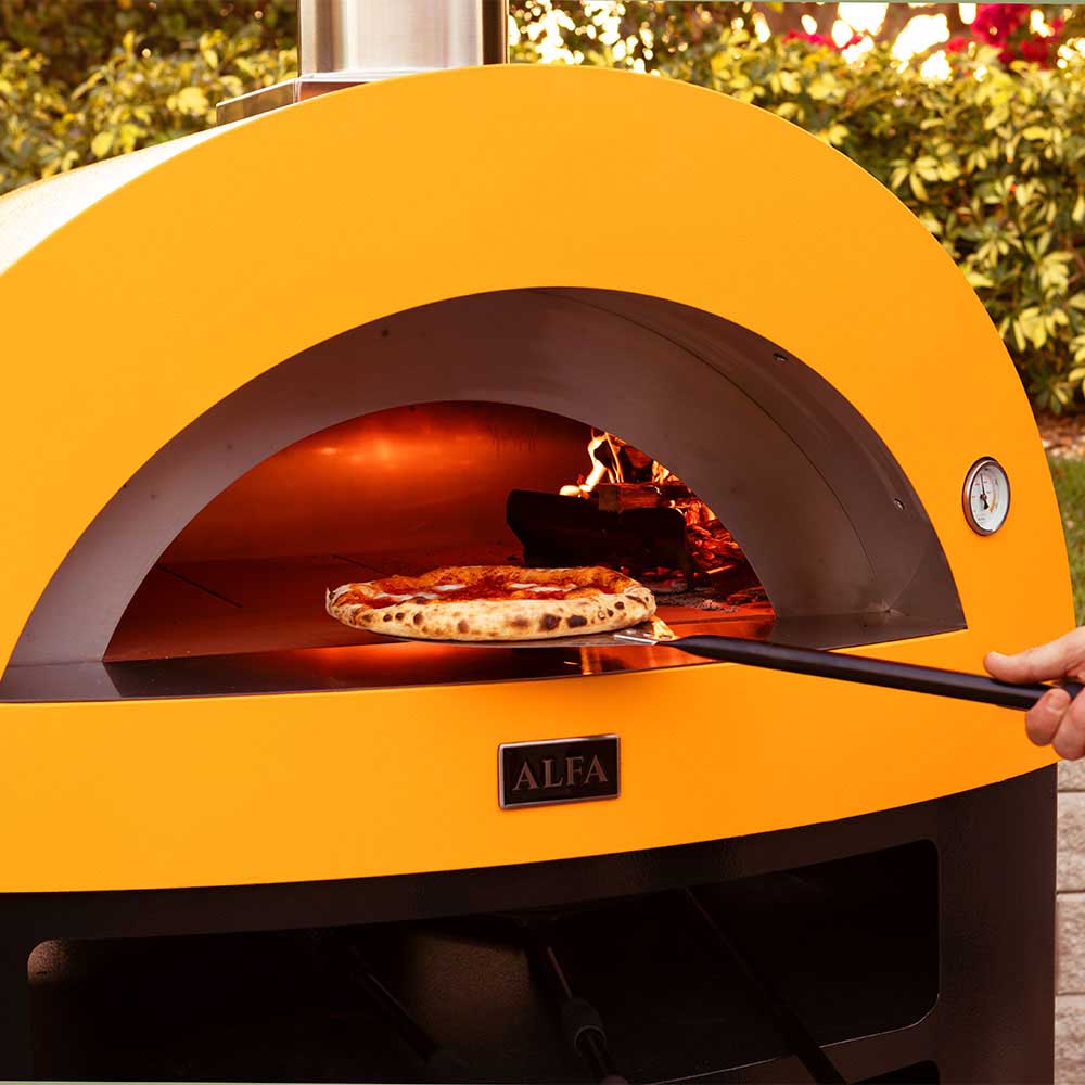 Freestanding natural gas pizza oven interior with pizza baking under orange flames