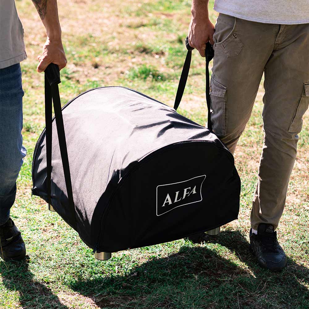 Black ALFA pizza oven cover bag being carried on grass, front logo panel