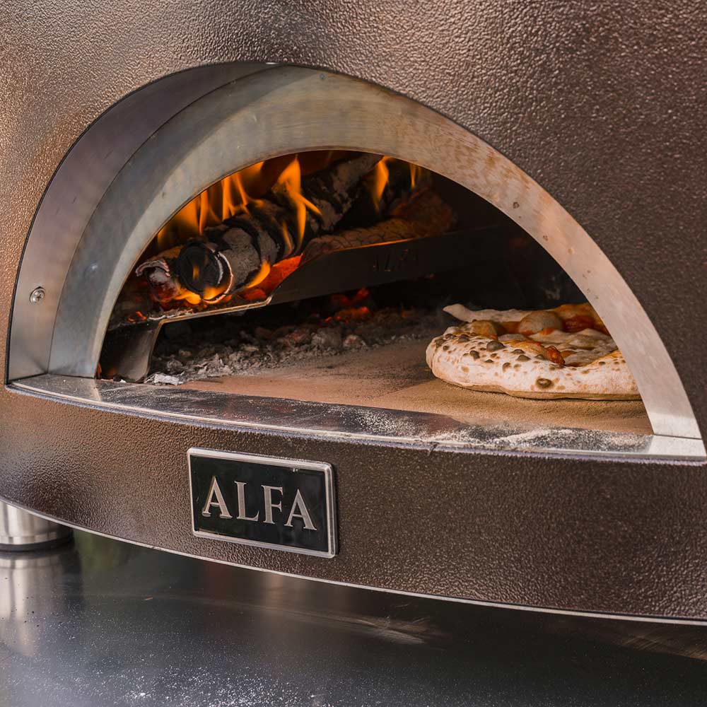 Close-up of wood-fired oven interior with flames and pizza crust on the hearth