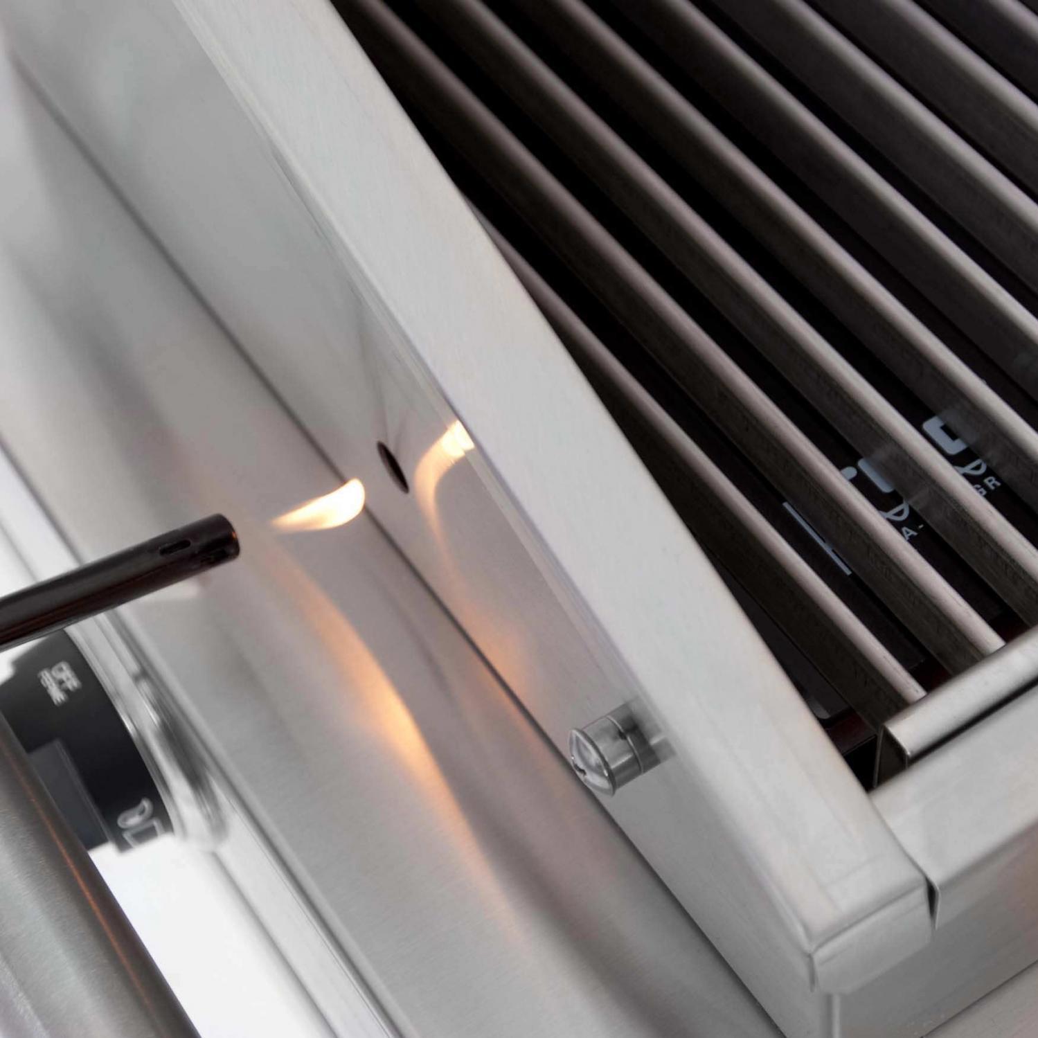 Stainless steel grill side control knob beside cooking grate and burner opening