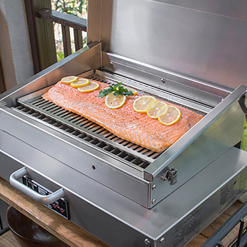 Infrared grill tray insert with metal grid and handle, holding sliced citrus-topped food.