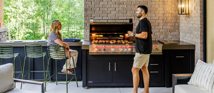 Chef cooking on a built-in gas grill in an outdoor kitchen