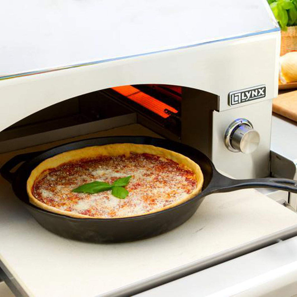 Pizza oven with open chamber holding a pizza on a round stone tray