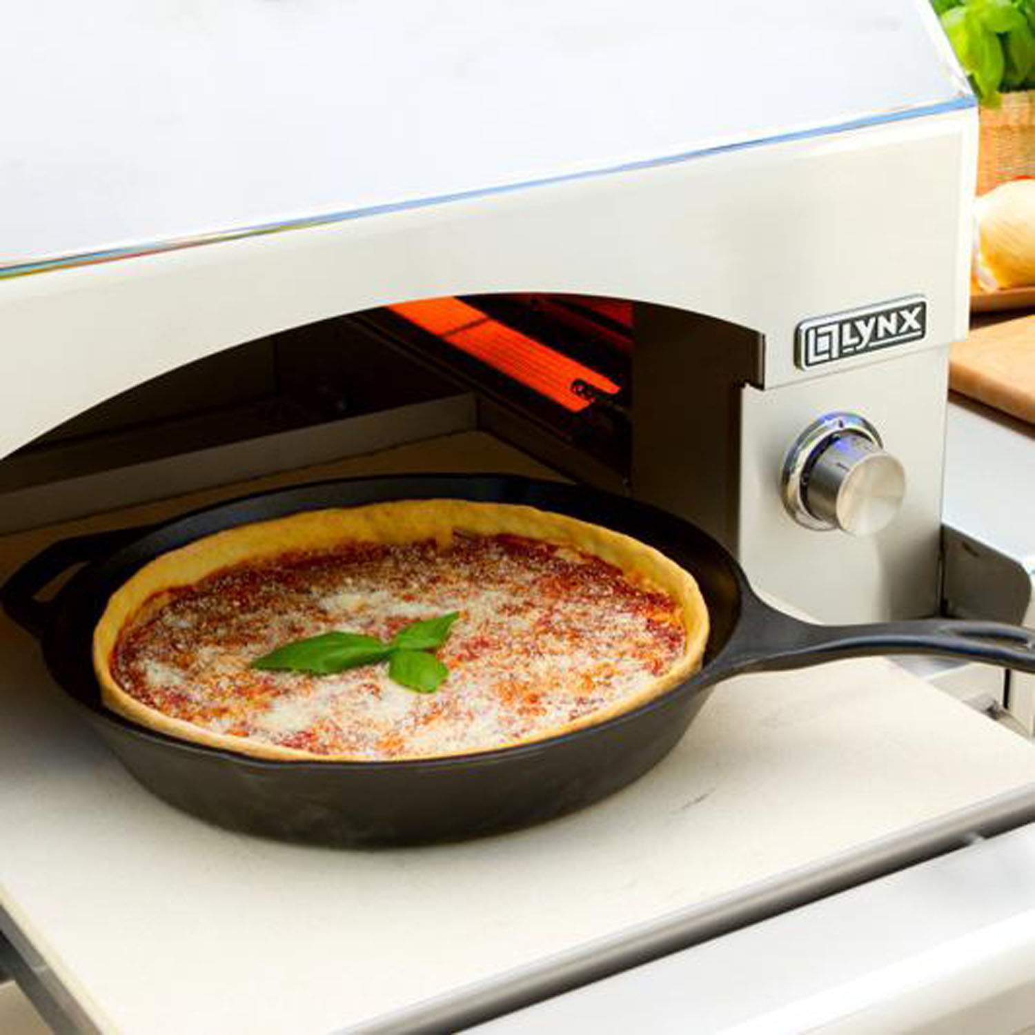Pizza oven with open chamber holding a pizza on a round stone tray