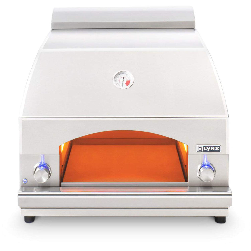 White pizza oven with orange glowing interior, LYNX badge, and side control knobs