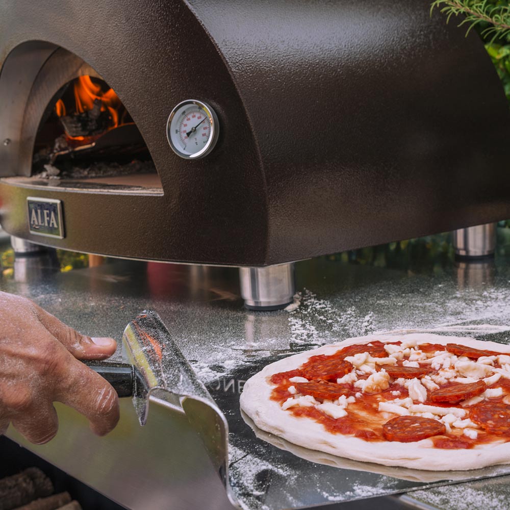 Alfa Nano oven interior with flames, thermometer, and pizza on metal peel