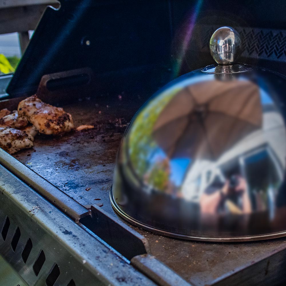 Stainless steel cooking dome lid on grill grate