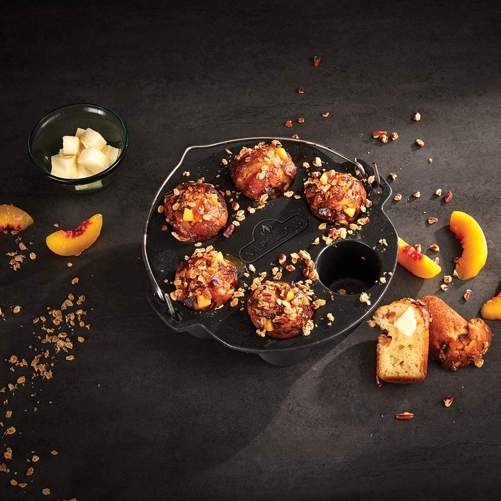 Cast iron muffin cooker with six muffins, browned tops in the round cup wells