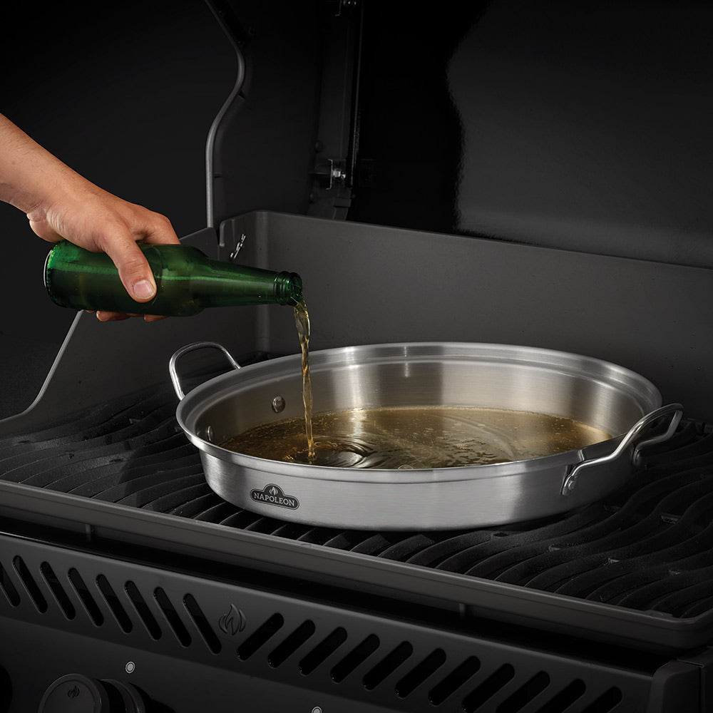Infusion roaster pan on grill with oil being poured into the interior