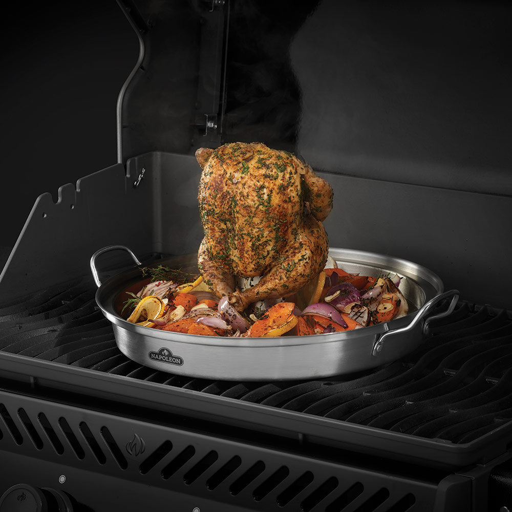 Infusion roaster pan holding a seasoned whole chicken with vegetables