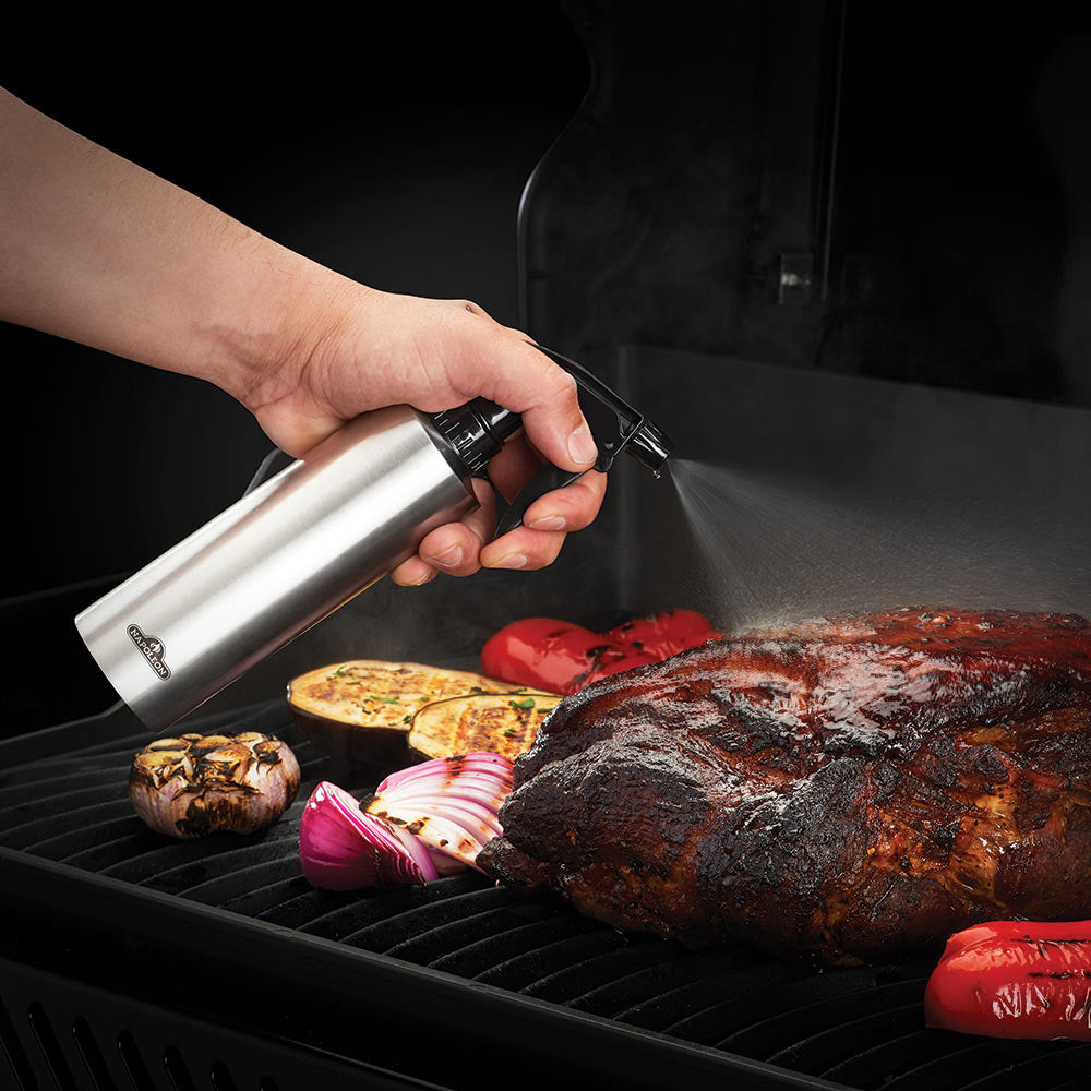 Stainless steel spray bottle held over grill for misting