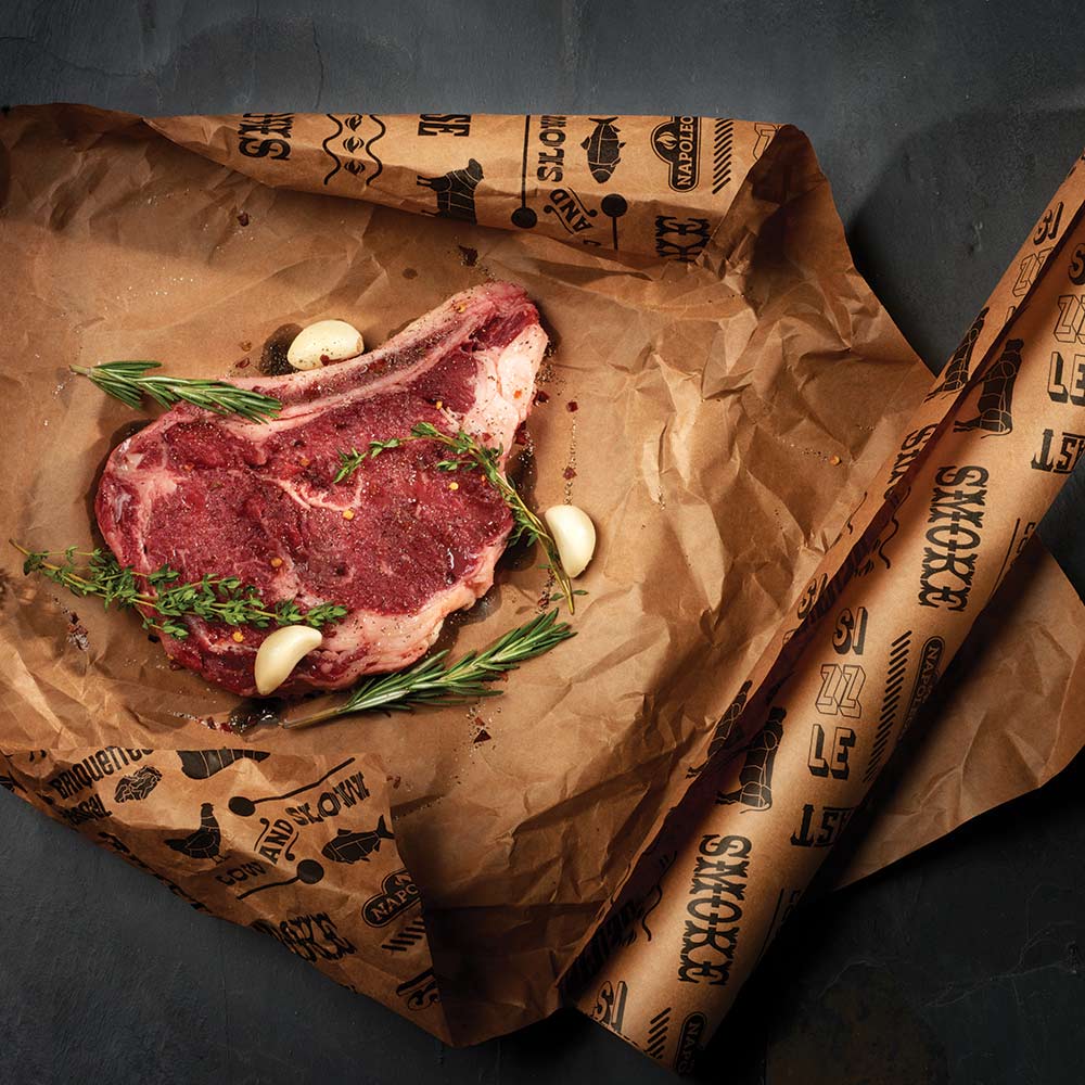 Brown butcher paper roll wrapped around meat, crinkled with black logo text pattern.