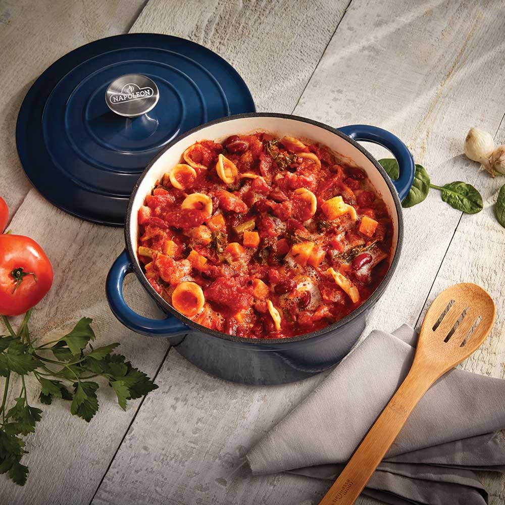 Blue cast iron round casserole dish with baked food and open lid