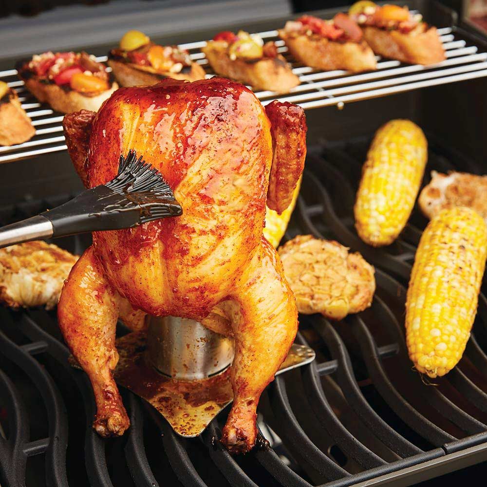 Chicken roaster with a whole seasoned chicken on a grill