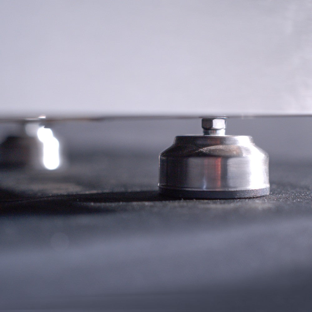 Close-up of gas burner beneath the griddle plate with metal control shield