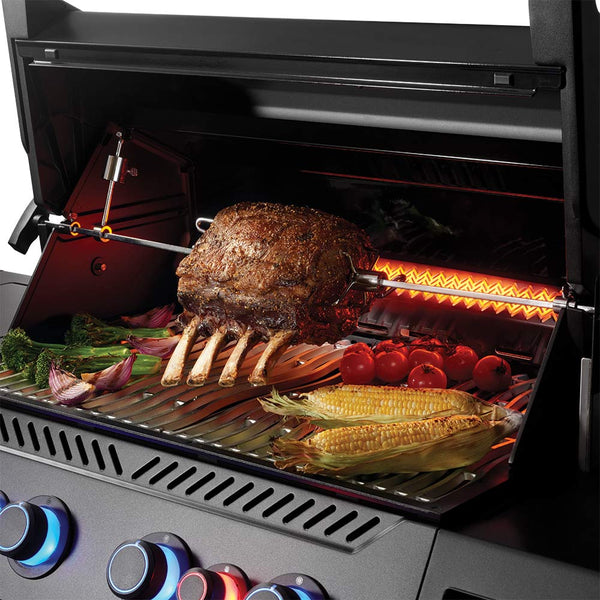 Napoleon gas grill interior with roasted chicken, corn, tomatoes, and vegetables on grates