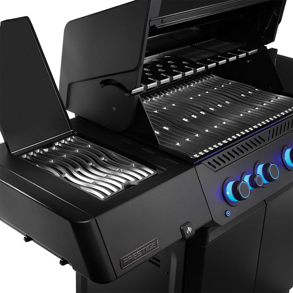 Napoleon Prestige gas grill with open hood, stainless cooking grates, and control knobs